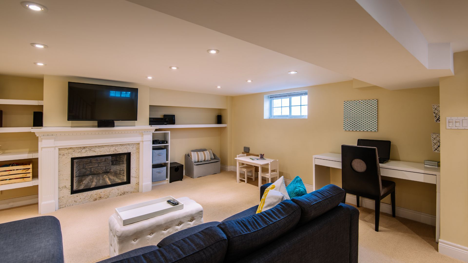 Luxury finished basement with fireplace, recessed lighting, and sectional sofa remodeled by Myers Home Improvements CT