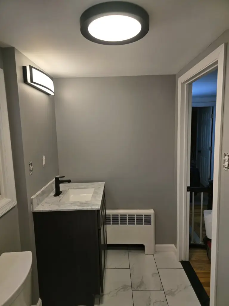 Remodeled Bristol CT bathroom with dark vanity, black faucet, and new ceiling lighting