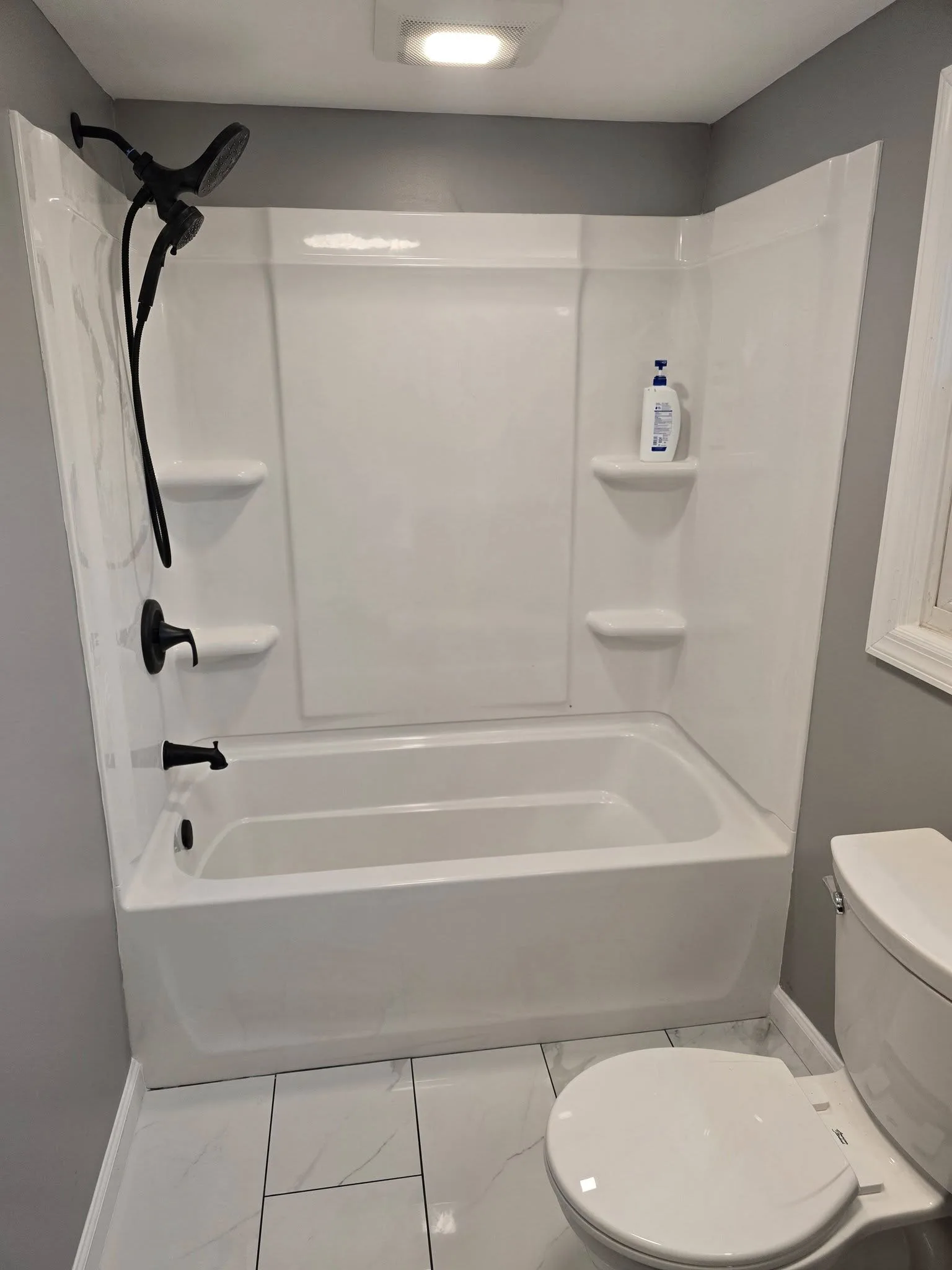 New tub and shower surround with matte black fixtures in a remodeled Bristol CT bathroom