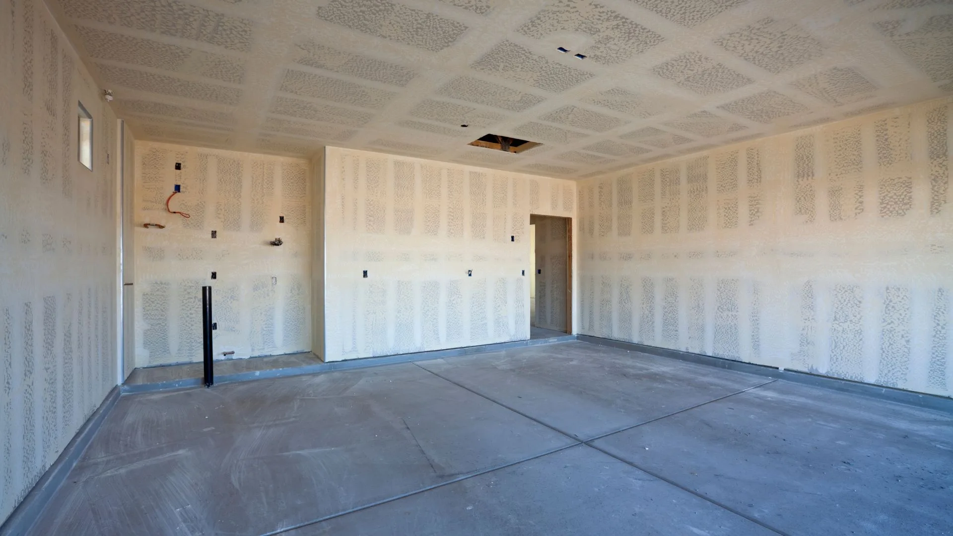 Freshly hung and taped drywall in an interior room renovation