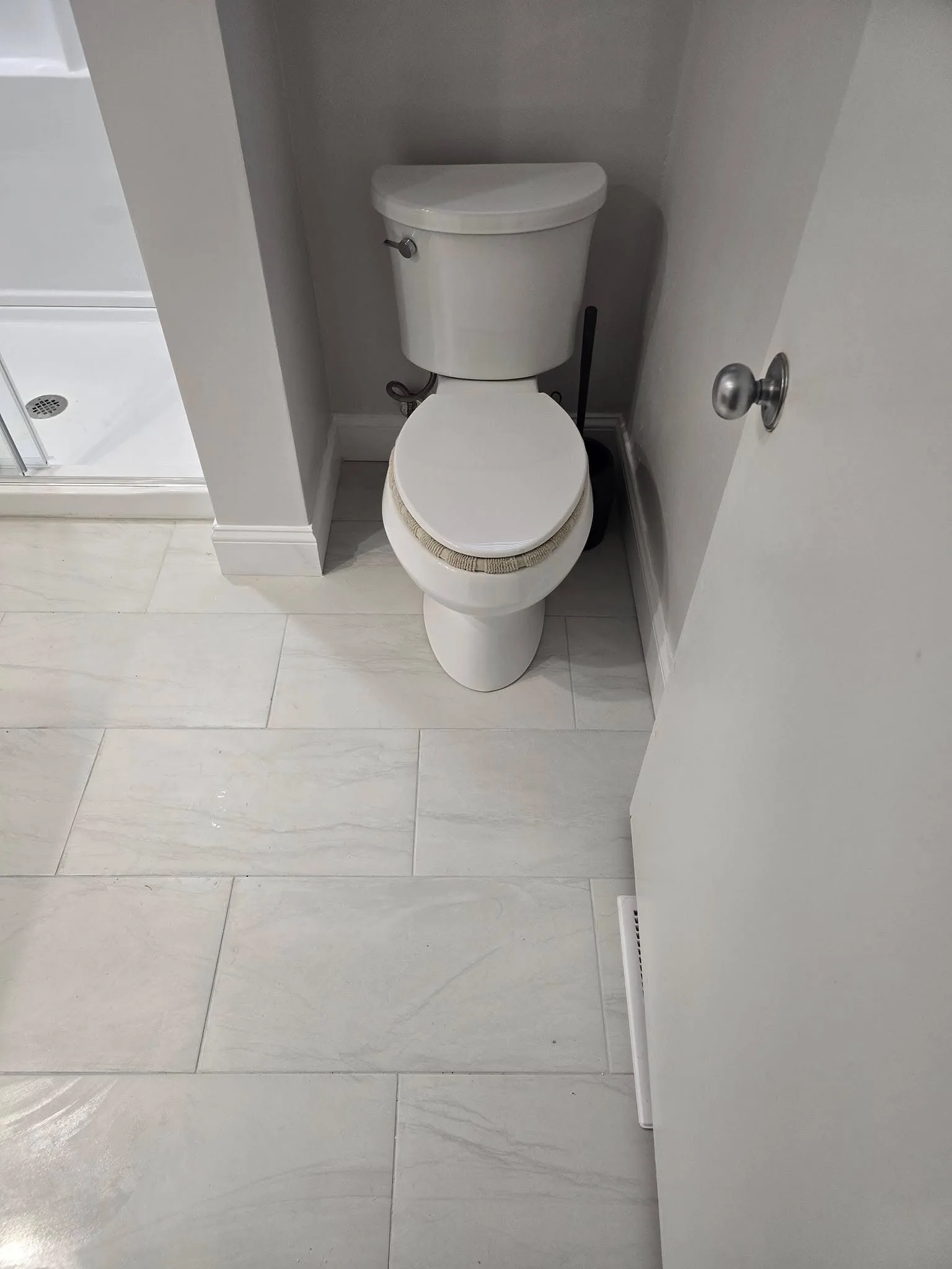 New water-efficient toilet and marble-look tile in a remodeled Simsbury CT bathroom