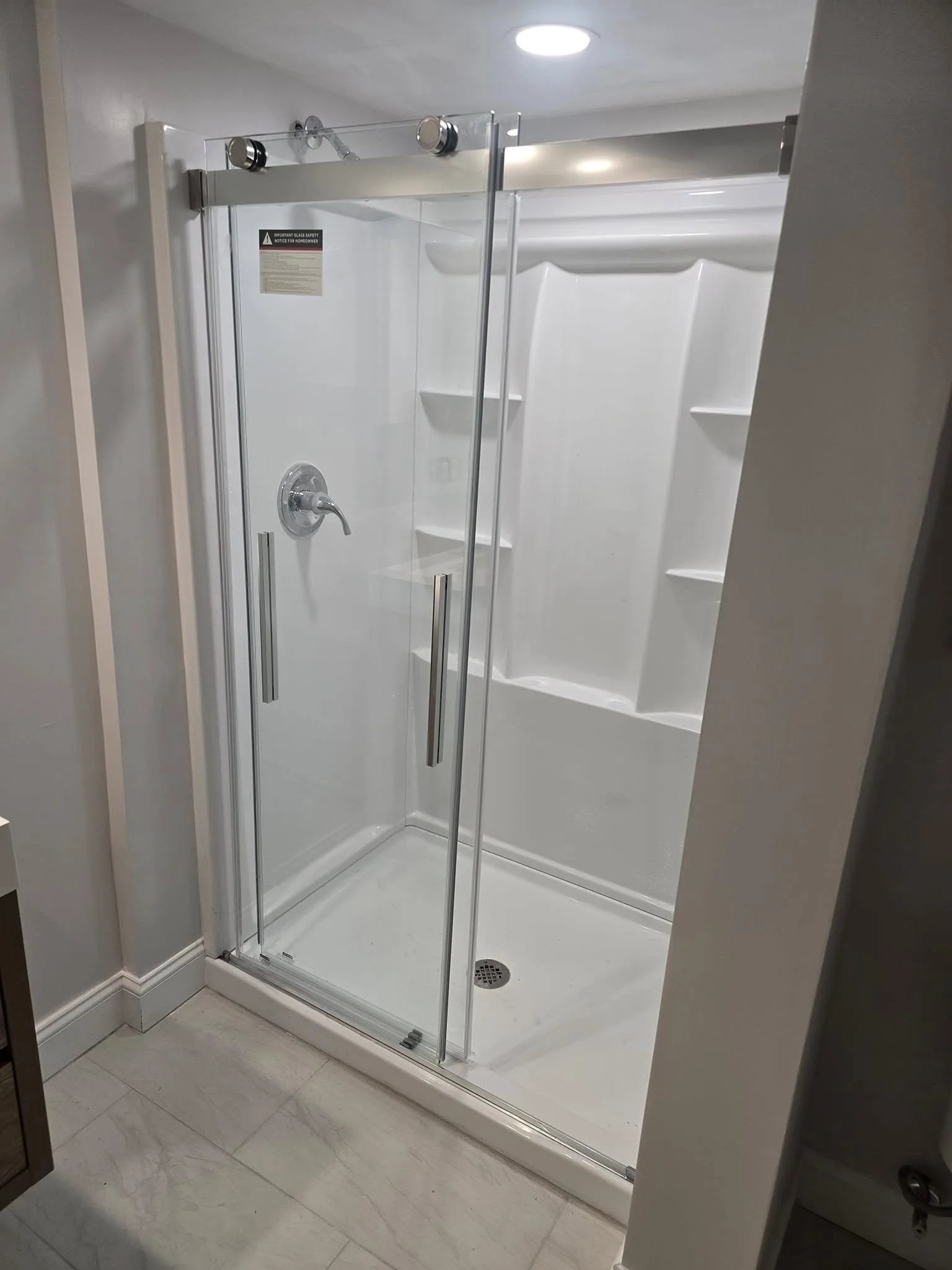New white shower with sliding glass door in a remodeled Simsbury CT bathroom