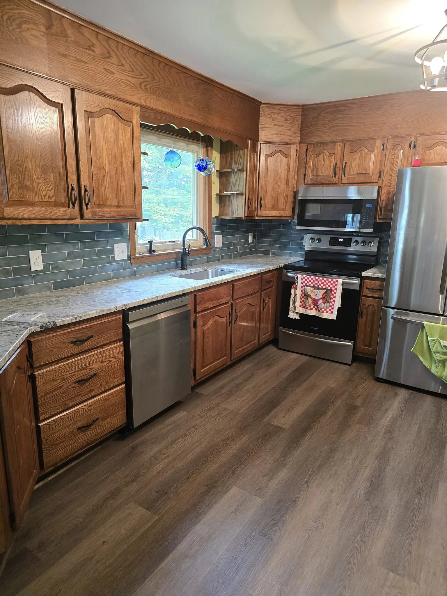 Updated Wethersfield CT kitchen with blue-gray subway tile backsplash and granite countertops