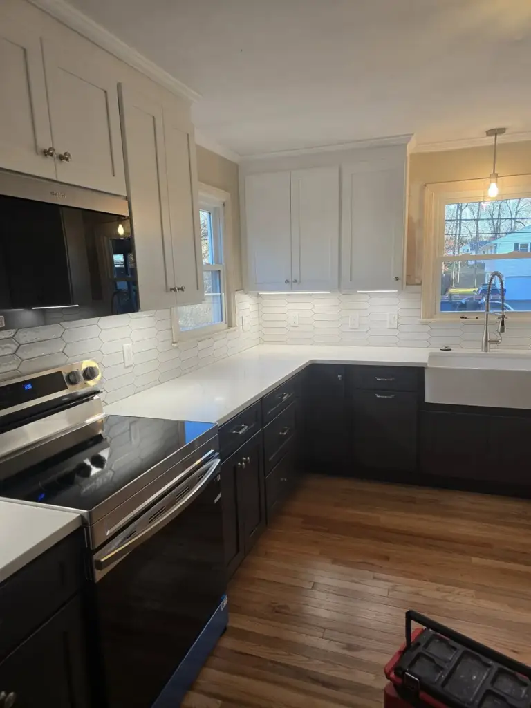 Remodeled West Hartford CT two-tone kitchen with white uppers, dark bases, and picket tile backsplash
