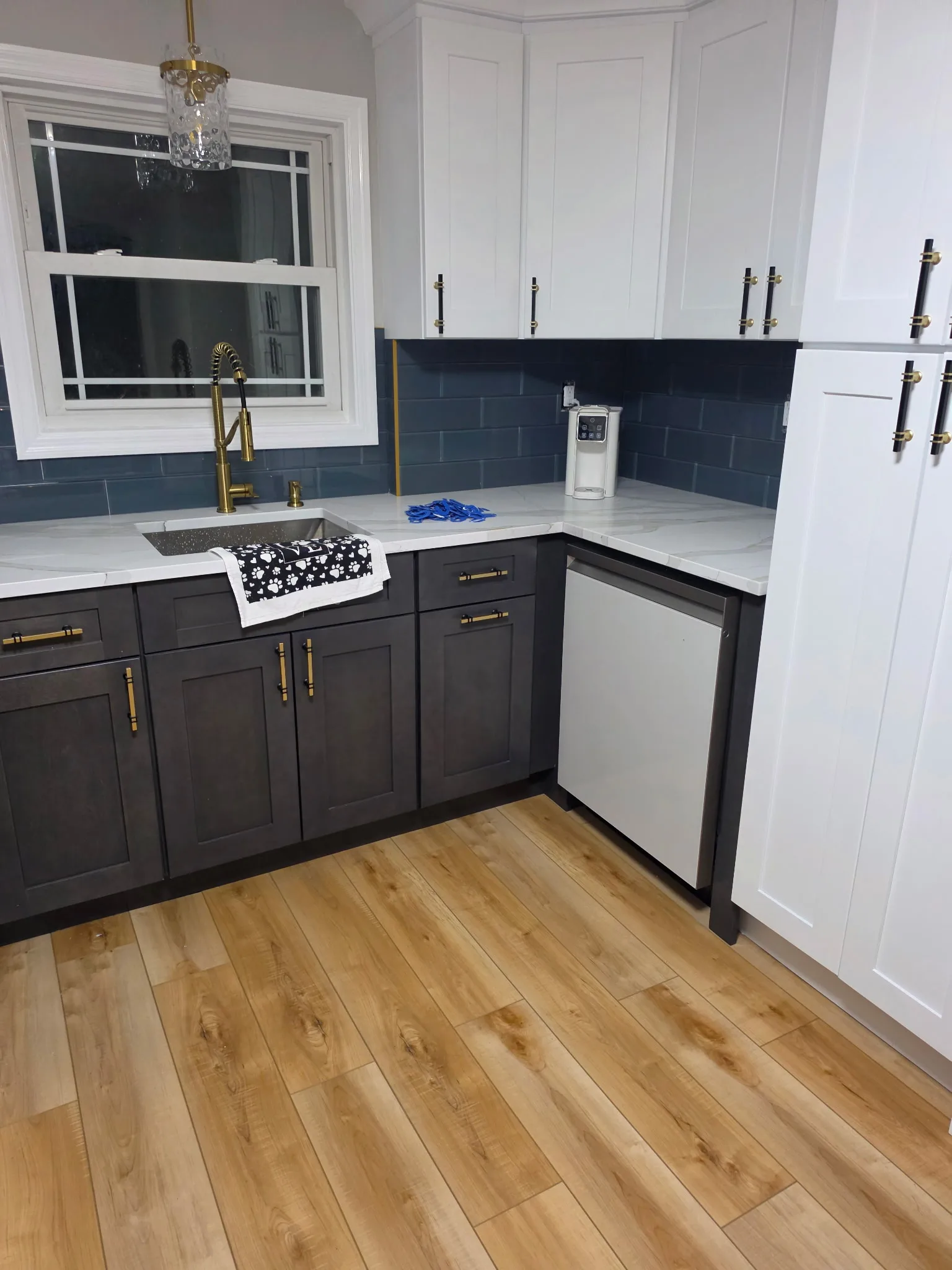 New dishwasher and white pantry cabinets beside charcoal sink cabinets in a Bristol CT kitchen remodel