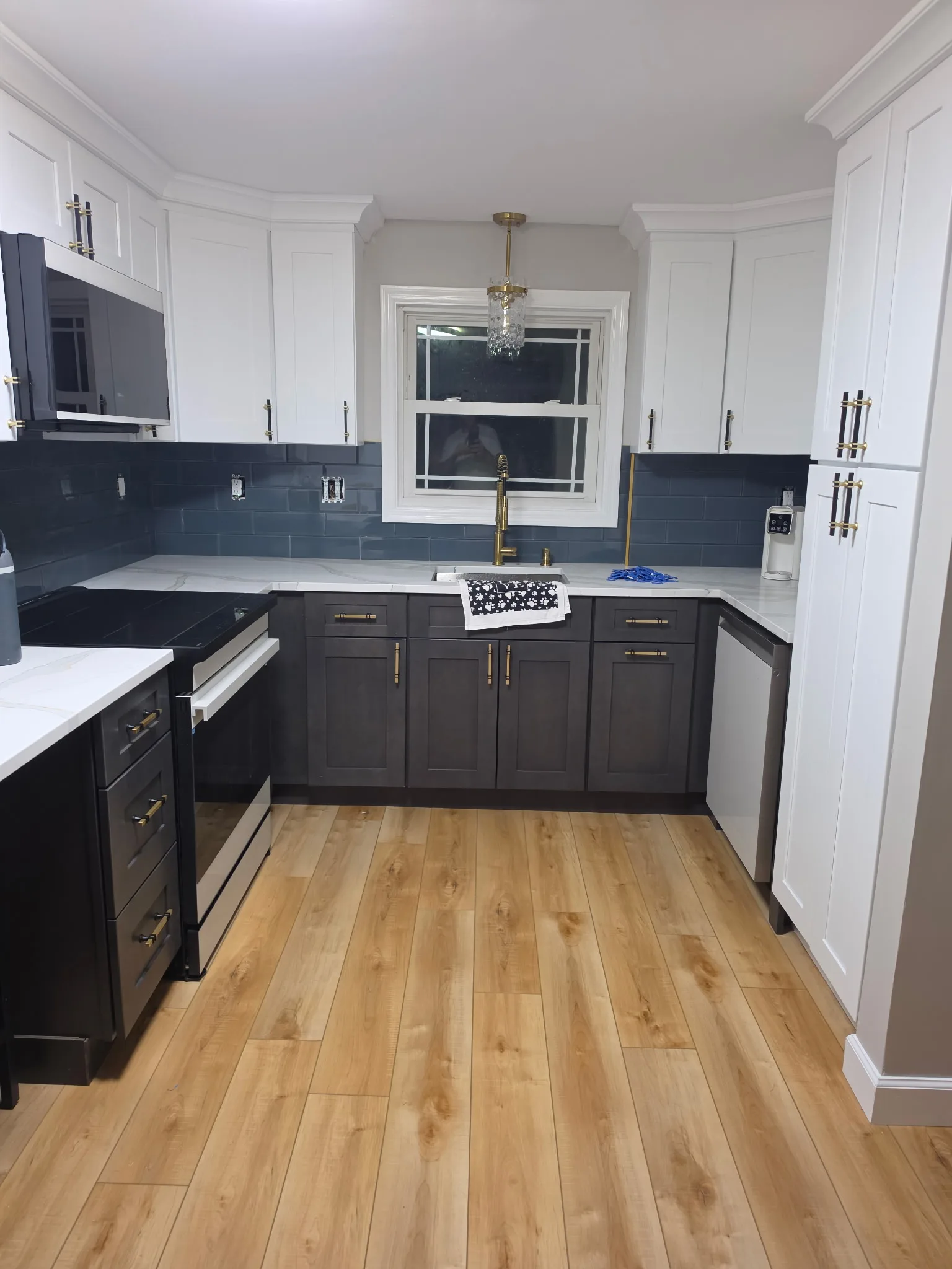 Remodeled Bristol CT kitchen with white shaker uppers, charcoal base cabinets, quartz counters, and brass hardware