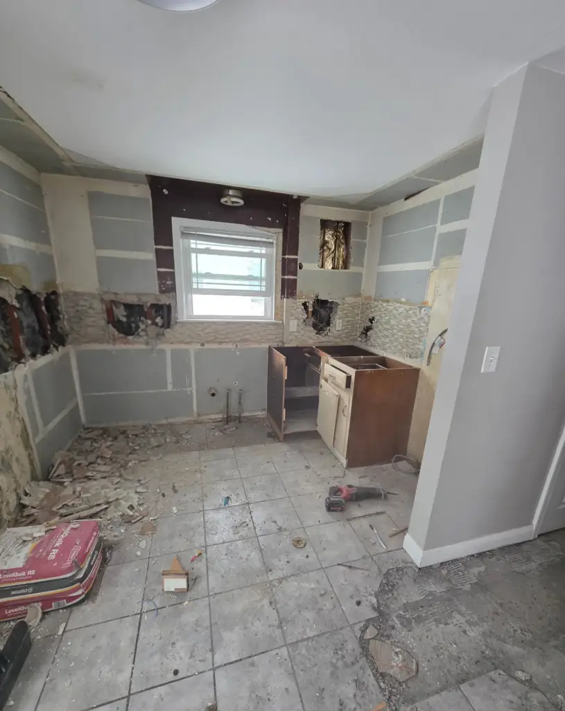 Bristol CT kitchen before remodeling, gutted to bare walls with old base cabinets and worn tile floor