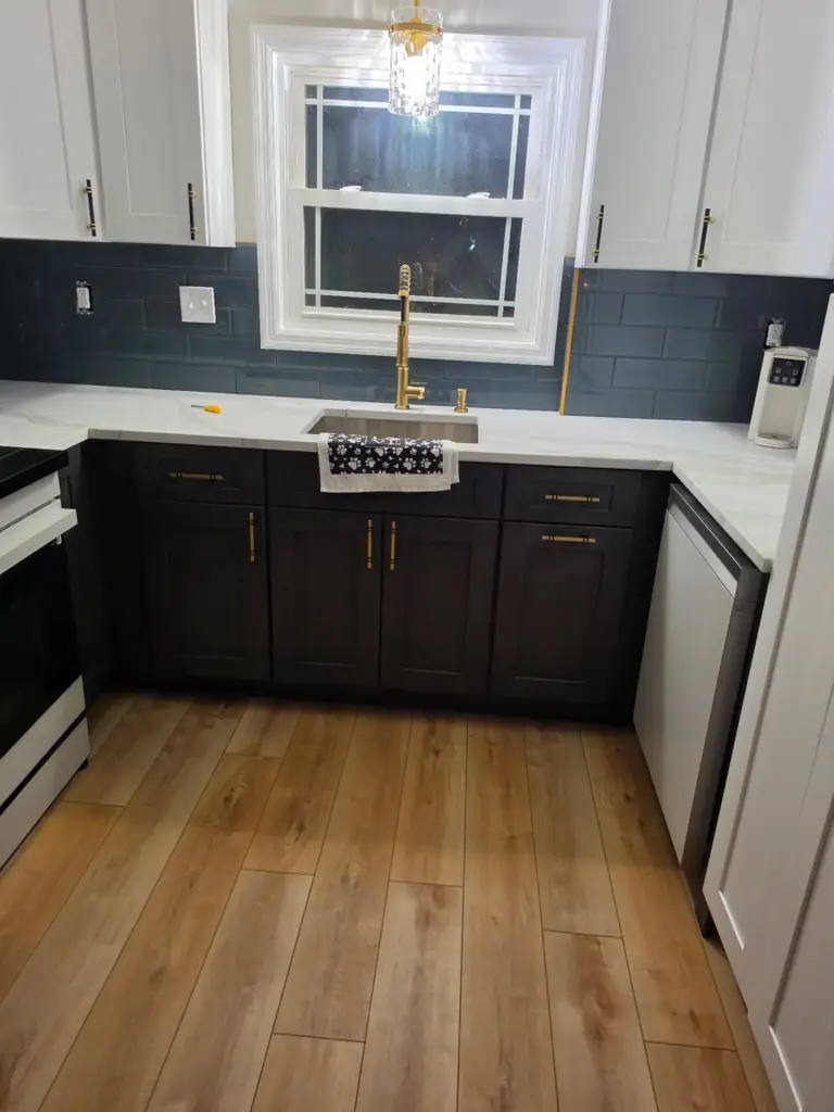 Undermount sink with brass faucet under the window in a remodeled Bristol CT kitchen