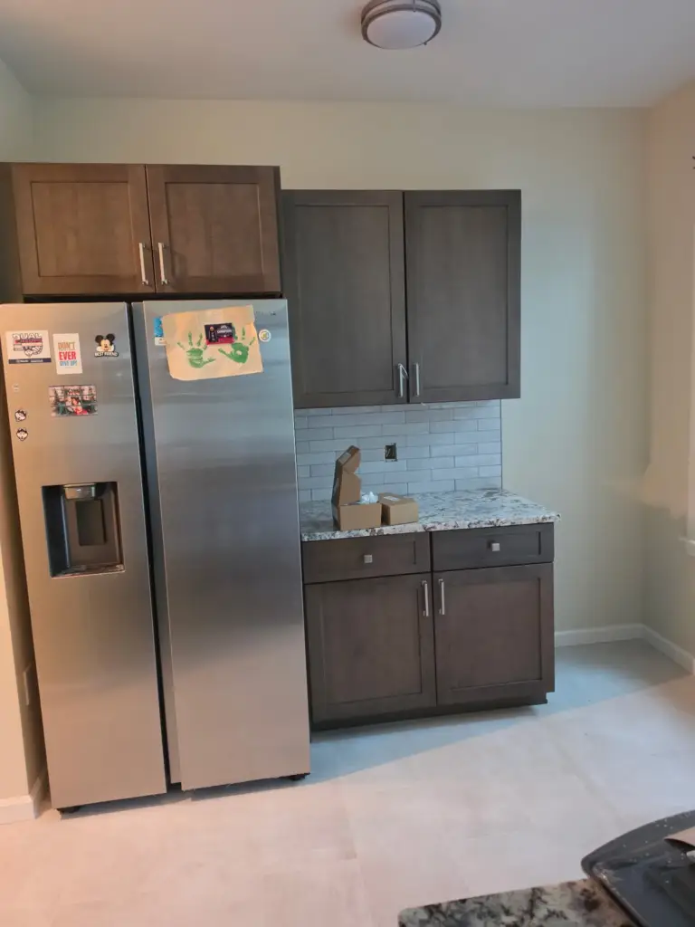 New pantry-side cabinets and granite counter beside the refrigerator in a Cromwell CT kitchen remodel