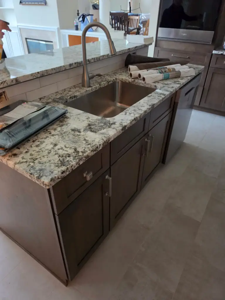 Undermount stainless sink in a granite-topped island from a Cromwell CT kitchen remodel