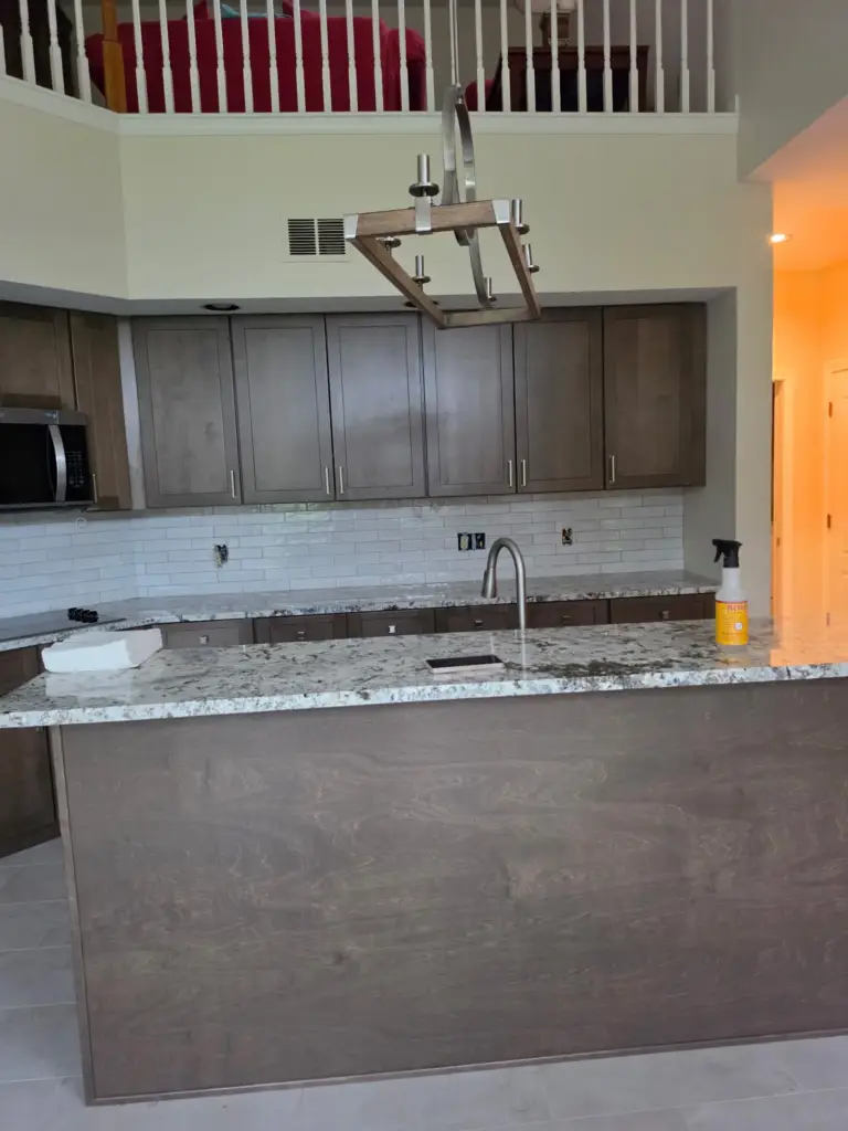 New kitchen island with granite countertop and pendant lighting in a Cromwell CT condo remodel
