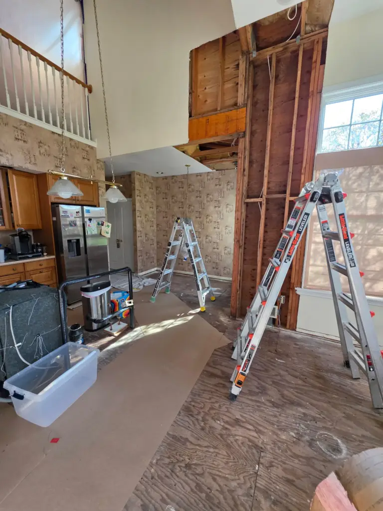 Cromwell CT condo kitchen before remodeling with dated cabinets, wallpaper, and exposed subfloor