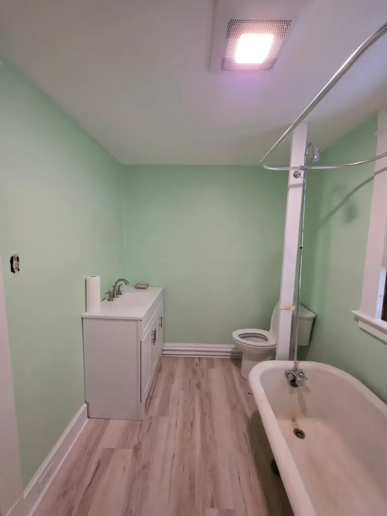 Remodeled Torrington CT bathroom with new vanity, new toilet, LVP flooring, and fresh paint