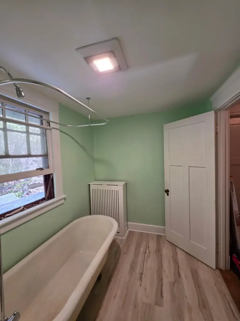 Remodeled Torrington CT bathroom with new LVP flooring, painted walls, and exhaust fan with light